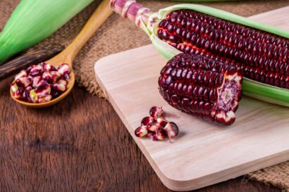 Fresh corn on cobs on rustic wooden table, closeup